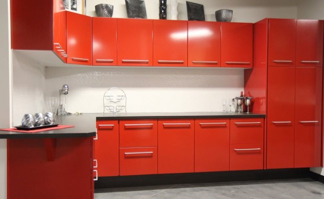 Красная угловая кухня с черной столешницей