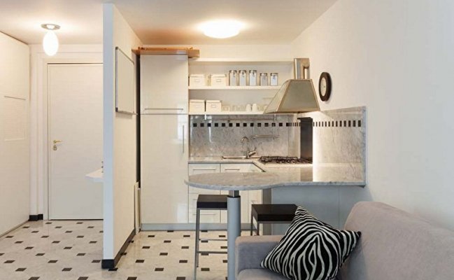 Небольшая светлая угловая кухня с барной стойкой 