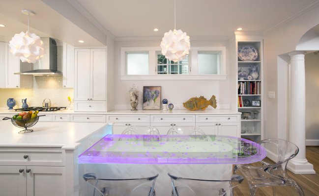 Кухня с белыми фасадами и стеклянной столешницей в обеденной зоне