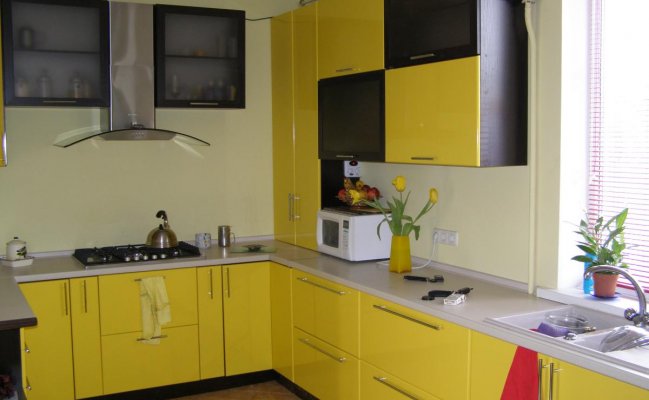 Небольшая п-образная кухня с жёлтыми фасадами 