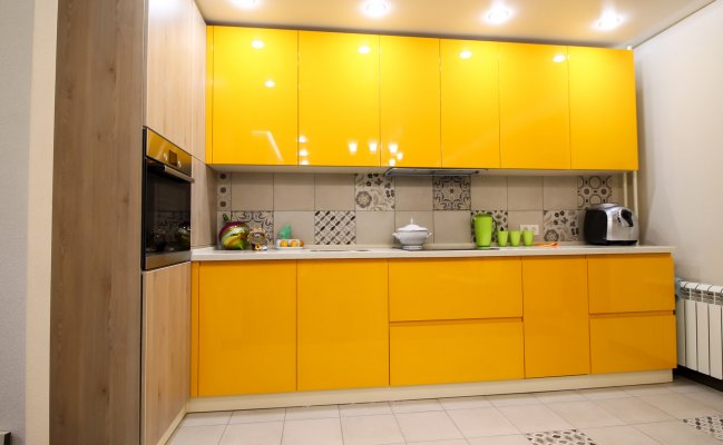 Небольшая желтая кухня с фартуком плиткой