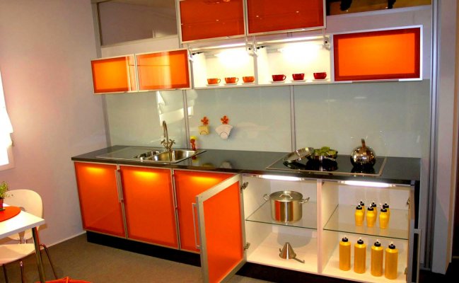 Небольшая кухня с оранжевыми стеклянными фасадами